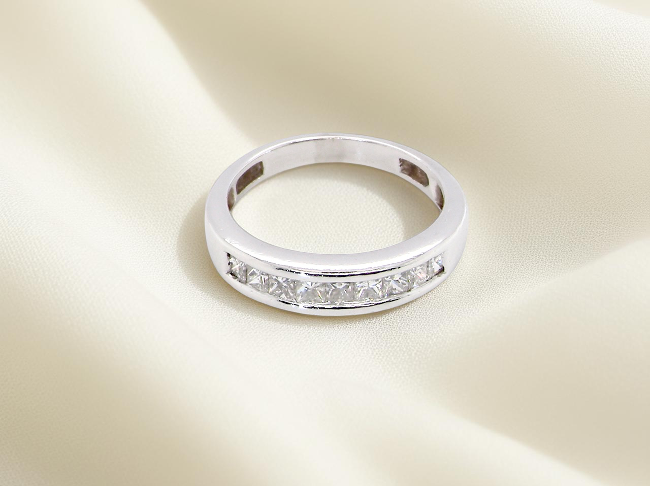 top view An elegant half-hoop eternity ring set with nine princess-cut white diamonds, each measuring approximately 2.5mm, with a total estimated diamond weight of 0.90 carats.