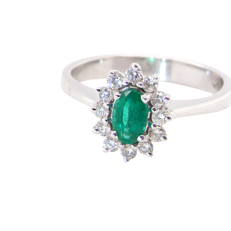 white gold cluster ring.
Centre stone is an oval cut emerald, 6x3.7mm (just under 0.50 carats) deep green hue.