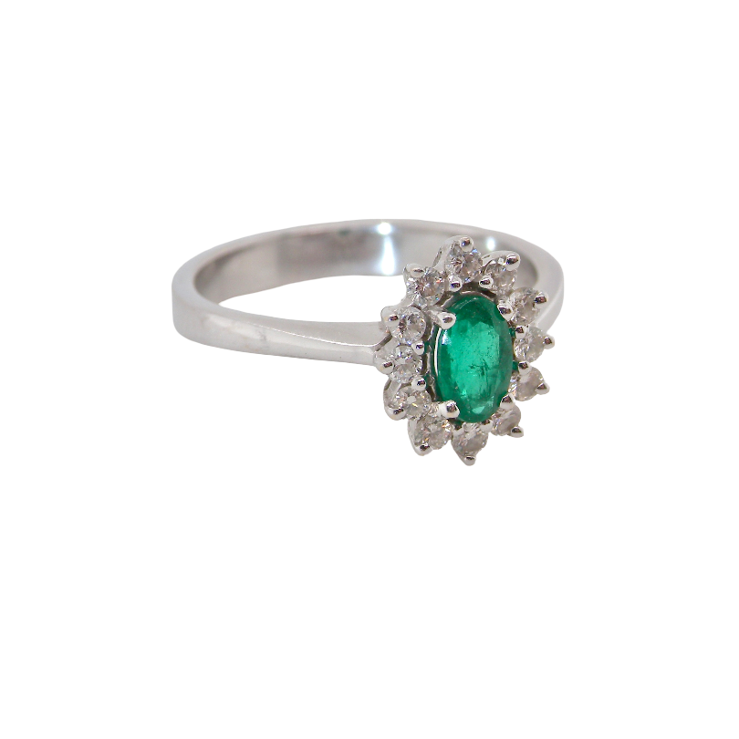 white gold cluster ring.
Centre stone is an oval cut emerald, 6x3.7mm (just under 0.50 carats) good deep green hue. side