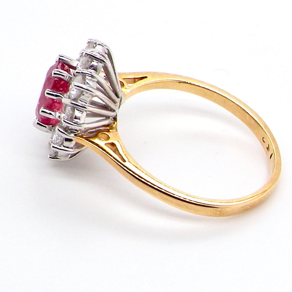 A classic cluster ring centred with an oval pinkish-red ruby measuring approximately 9 × 6 mm (estimated 1.75 carats)