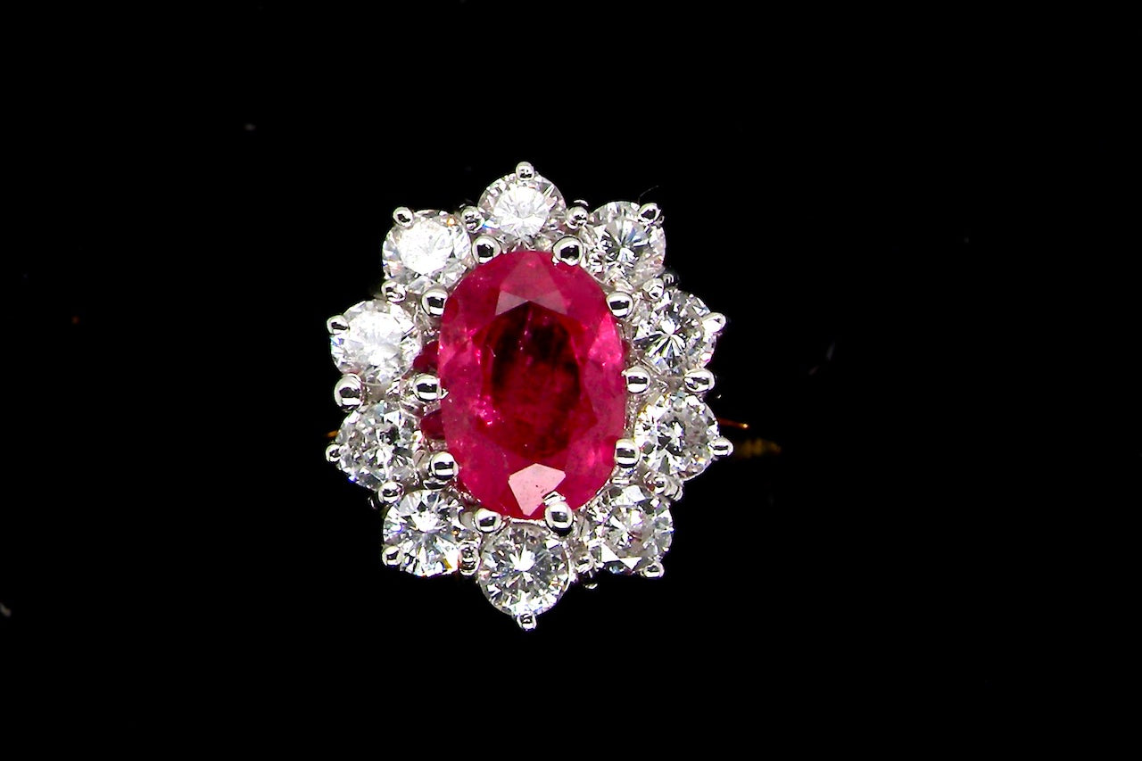 A classic cluster ring centred with an oval pinkish-red ruby measuring approximately 9 × 6 mm (estimated 1.75 carats)
