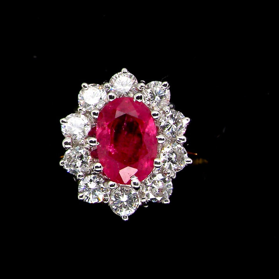 A classic cluster ring centred with an oval pinkish-red ruby measuring approximately 9 × 6 mm (estimated 1.75 carats)