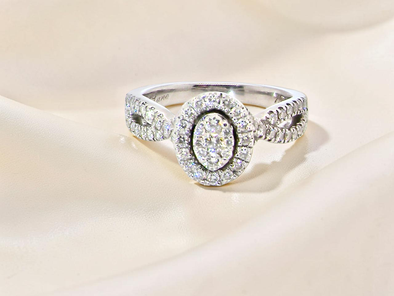 4 carat white gold cluster ring. The centre cluster an oval setting with nine small white diamonds.&nbsp;

Around the outside a halo of sixteen smaller diamonds, 