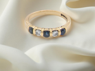 18-carat gold half-hoop eternity ring, set with round mid-blue sapphires
