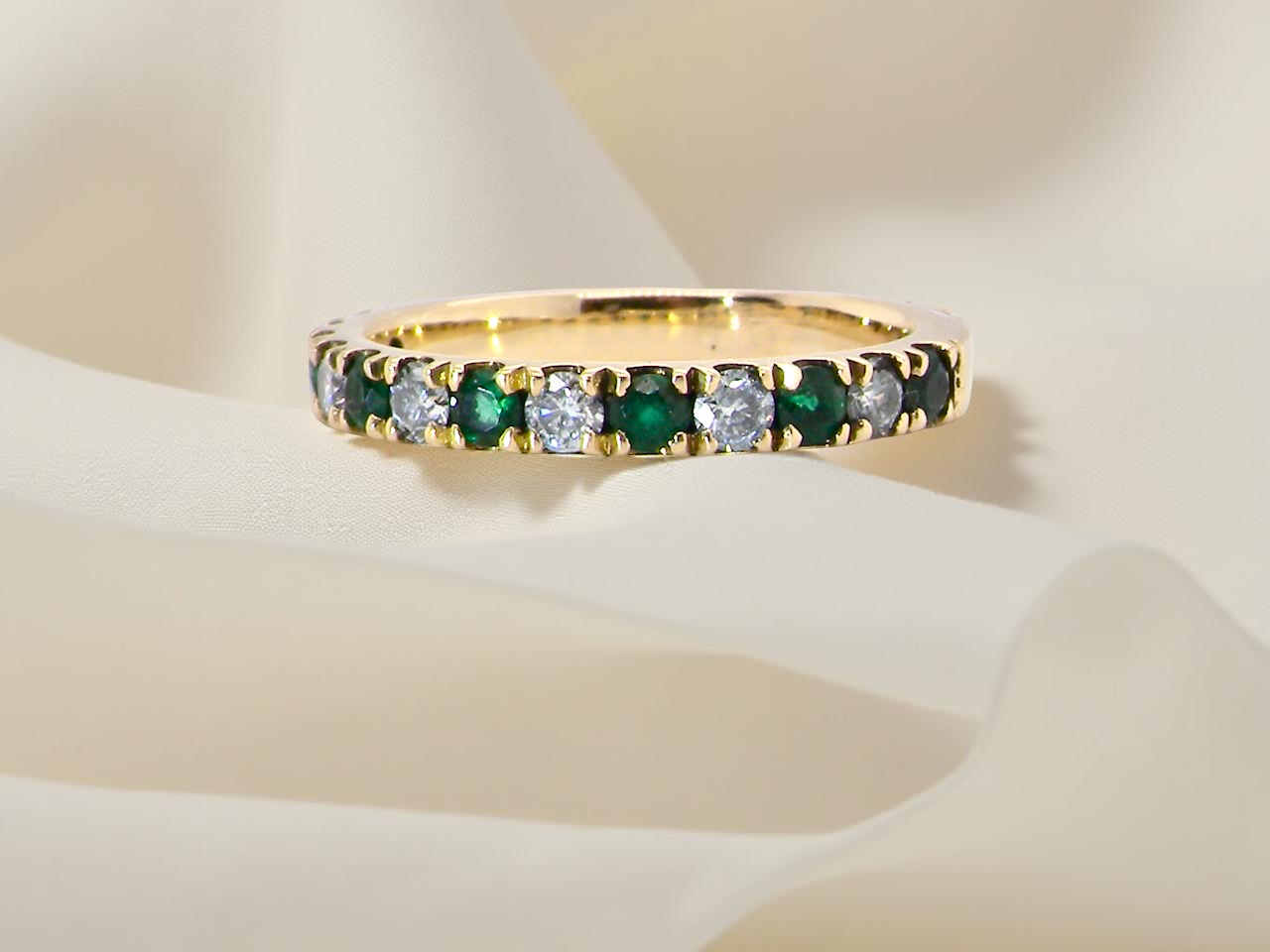 18 carat gold half-hoop eternity ring, set with&nbsp;six round-cut emeralds