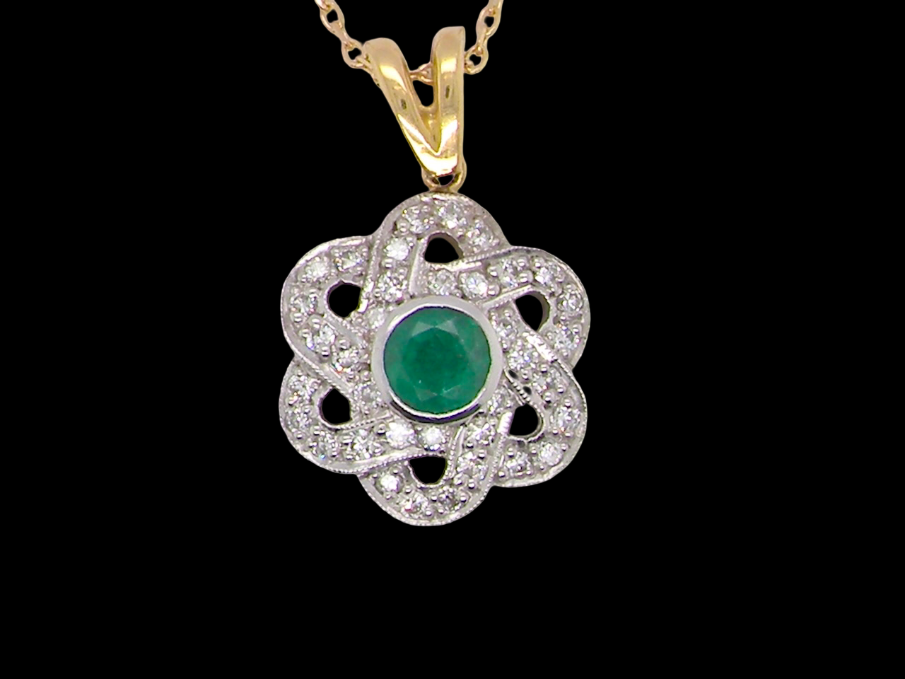 8 carat gold pendant that features to the centre a round emerald B