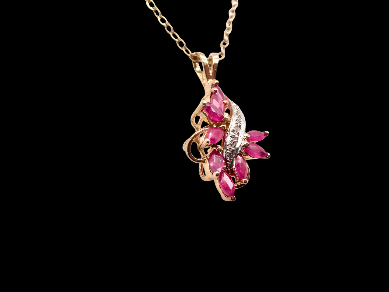 9 carat gold pendant. Features nine marquise rubies,