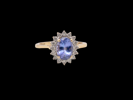 A 14 carat gold cluster ring. Features to the centre an oval cut cornflower blue sapphire, 8x6mm (est 1.25 carats), 