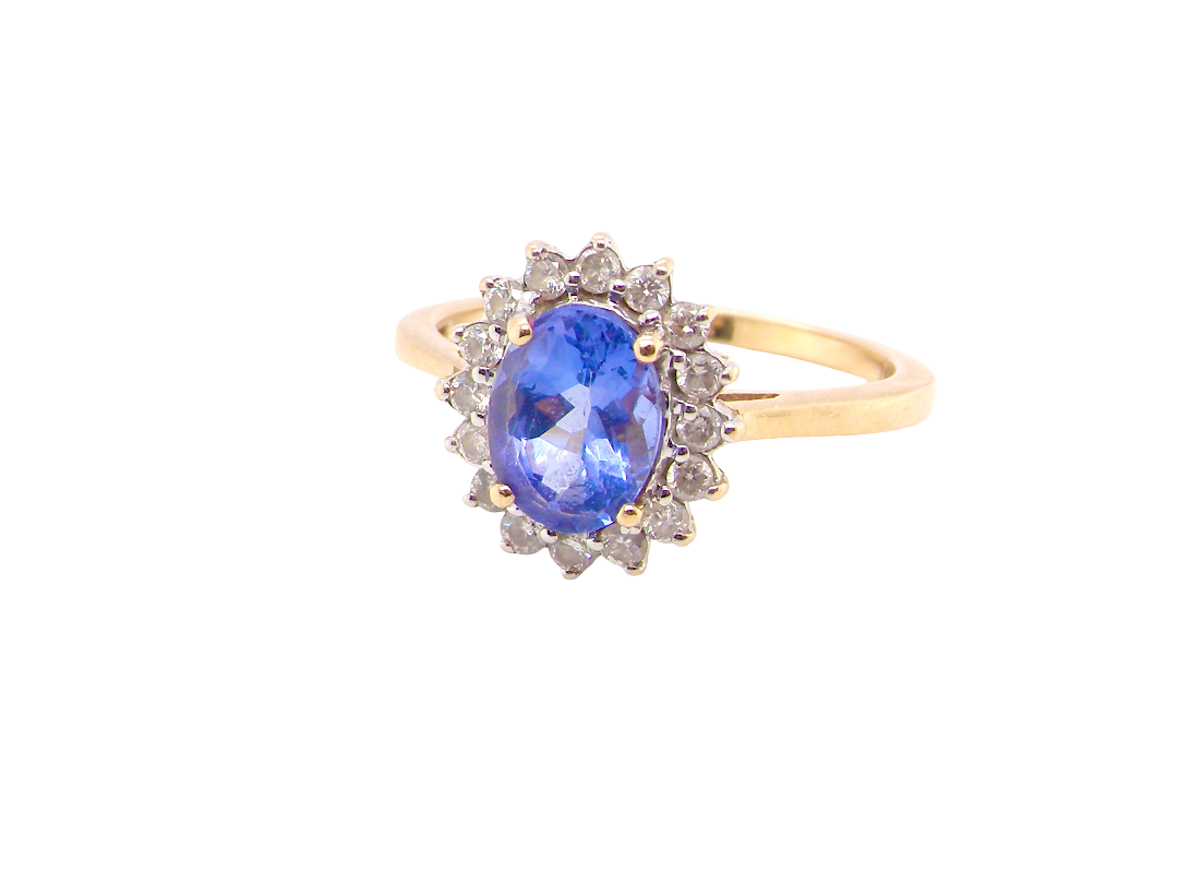 A 14 carat gold cluster ring. Features to the centre an oval cut cornflower blue sapphire, 8x6mm (, four claw setting.