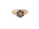 A 15 carat gold dress ring. The centre a small seed pearl, 3mm diameter. Surrounded by six sapphires, 