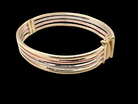 A 9 carat gold bangle with bands of rose, yellow and white gold 
