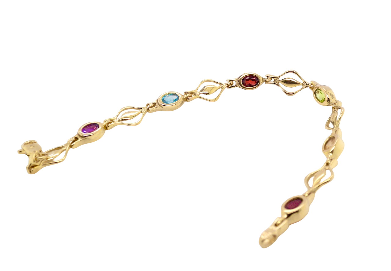 A 9 carat gold bracelet. Set with various gemstones, all oval cut.