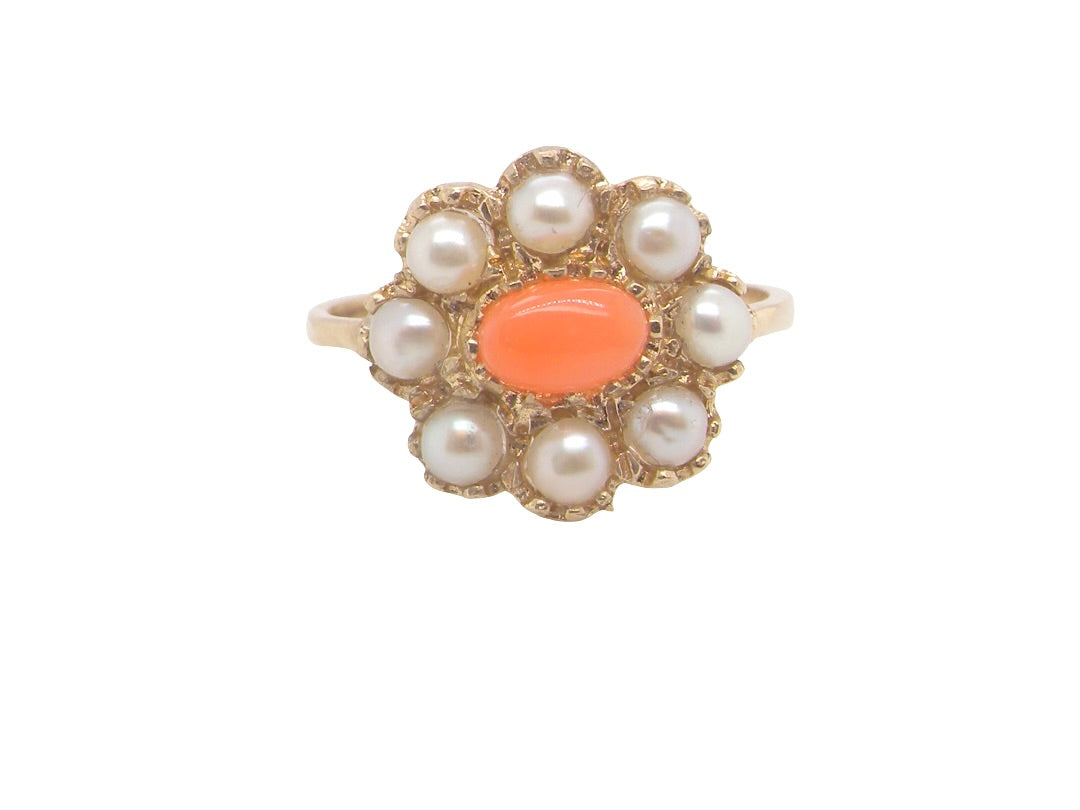 A 9 carat gold cluster ring. Centre stone an oval shaped coral stone 
