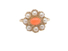 A 9 carat gold cluster ring. Centre stone an oval shaped coral stone 
