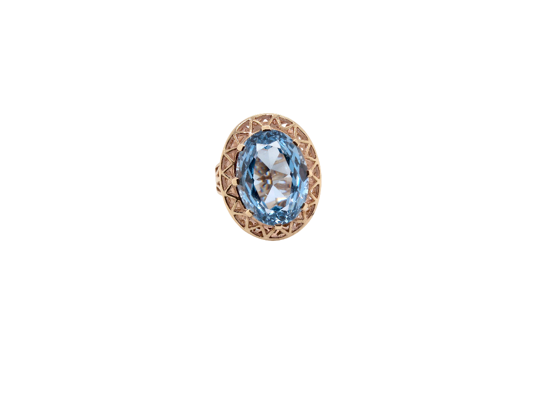 An oval ring featuring a light blue marquise-cut gemstone in a textured rose gold setting, shown against a plain white background.