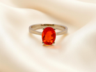 A 9 carat gold dress ring that features a vibrant fireglow fire opal. .