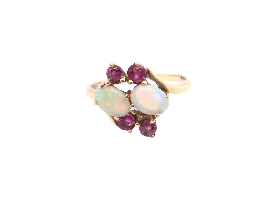 A 9 carat gold dress ring that features two oval white opals, each 7x5mm, and four rubies
