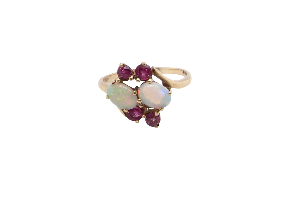 A 9 carat gold dress ring that features two oval white opals, each 7x5mm, and four rubies each 3.4mm.