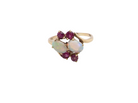 A 9 carat gold dress ring that features two oval white opals, each 7x5mm, and four rubies each 3.4mm.