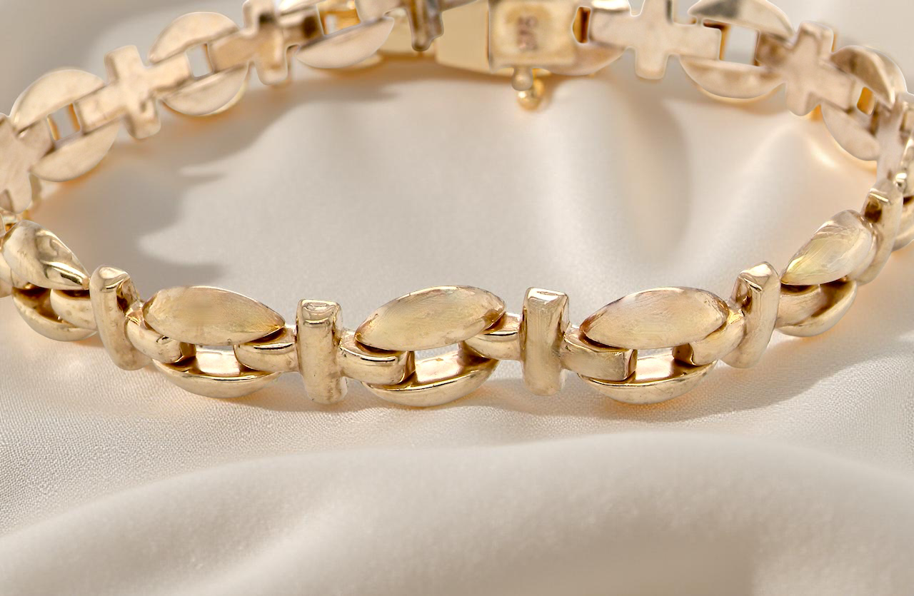 Gold bracelet on a light fabric background