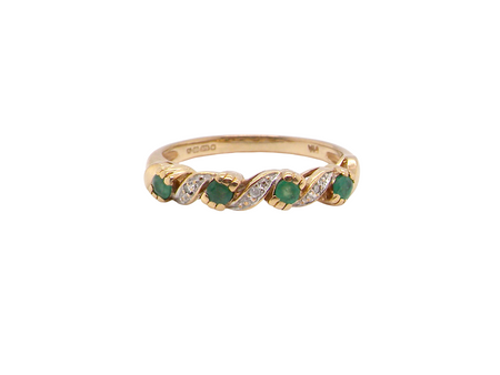 A 9 carat gold half hoop eternity ring. Set with four 2.4mm emeralds.

Set in alternate sections, a 'lazy S' design,