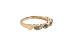 A 9 carat gold half hoop eternity ring. Set with four 2.4mm emeralds.

Set in alternate sections, a 'lazy S' design, side