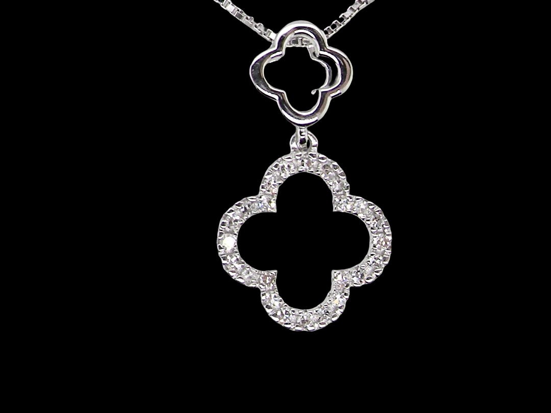 A 9 carat white gold pendant in the 'Alhambra' style. Set with twenty four small  diamonds, carat total 0.12 carats.