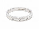 band ring with three small round-cut clear gemstones set in a row, photographed on a clean white background.