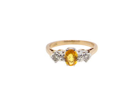 A yellow sapphire and diamond trilogy ring