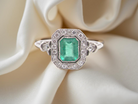 A beautiful Art Deco cluster ring centred with a step-cut emerald