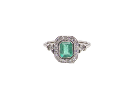 A beautiful Art Deco cluster ring centred with a vibrant step-cut emerald