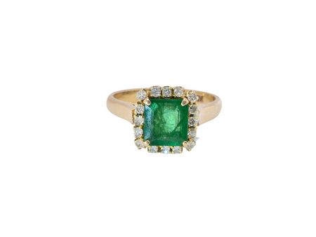 A beautiful cluster ring set with a large square-cut emerald measuring approximately 7 x 7mm, displaying a deep grass-green colour with natural inclusions, as expected in emeralds.