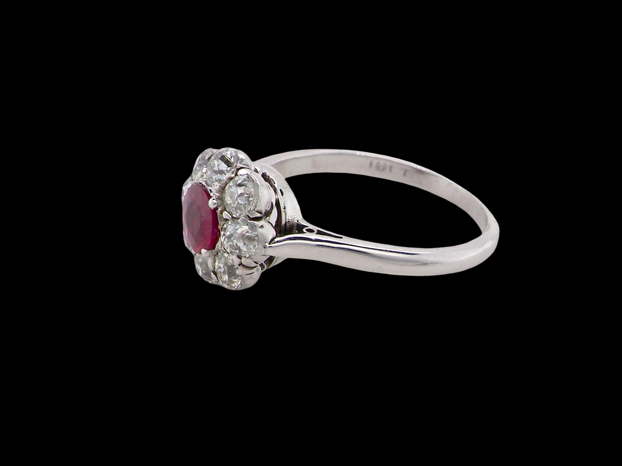 A beautiful cluster ring set with a raspberry-red ruby centre stone measuring 5mm in diameter, estimated at approximately 0.50 carats. side view