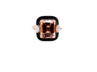 A rose gold ring featuring a large square-cut peach morganite center stone and two small round-cut clear accent stones on either side, set against a black background.