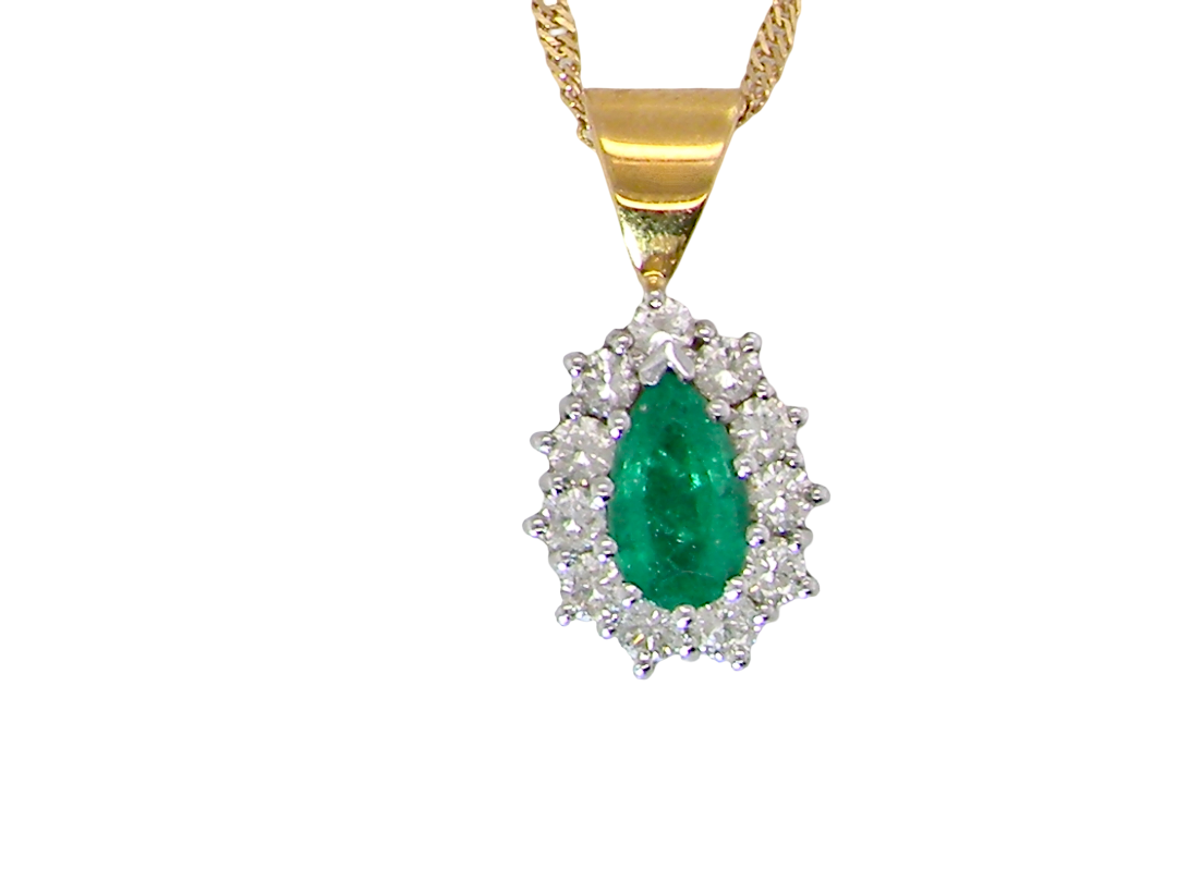 A gold pendant necklace featuring a pear-cut green emerald center stone surrounded by a halo of small clear stones, suspended from a gold chain against a plain white background.