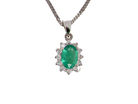 A beautiful traditional cluster pendant featuring an oval-cut emerald 