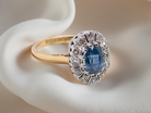 A beautiful cluster ring featuring an oval mid-blue sapphire 