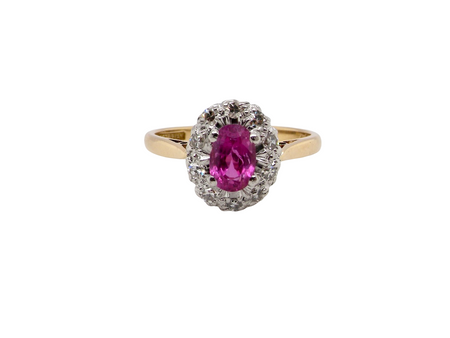 A beautiful vintage cluster ring showcasing a vivid pink sapphire centre stone, measuring approximately 6.6 × 4.3 mm(estimated 0.65 carats).