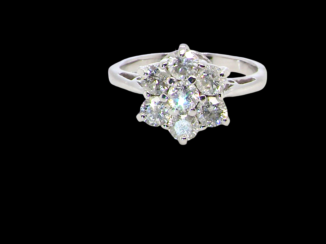 A beautiful vintage diamond cluster ring, elegantly set with seven brilliant-cut white diamonds in a floral cluster design.