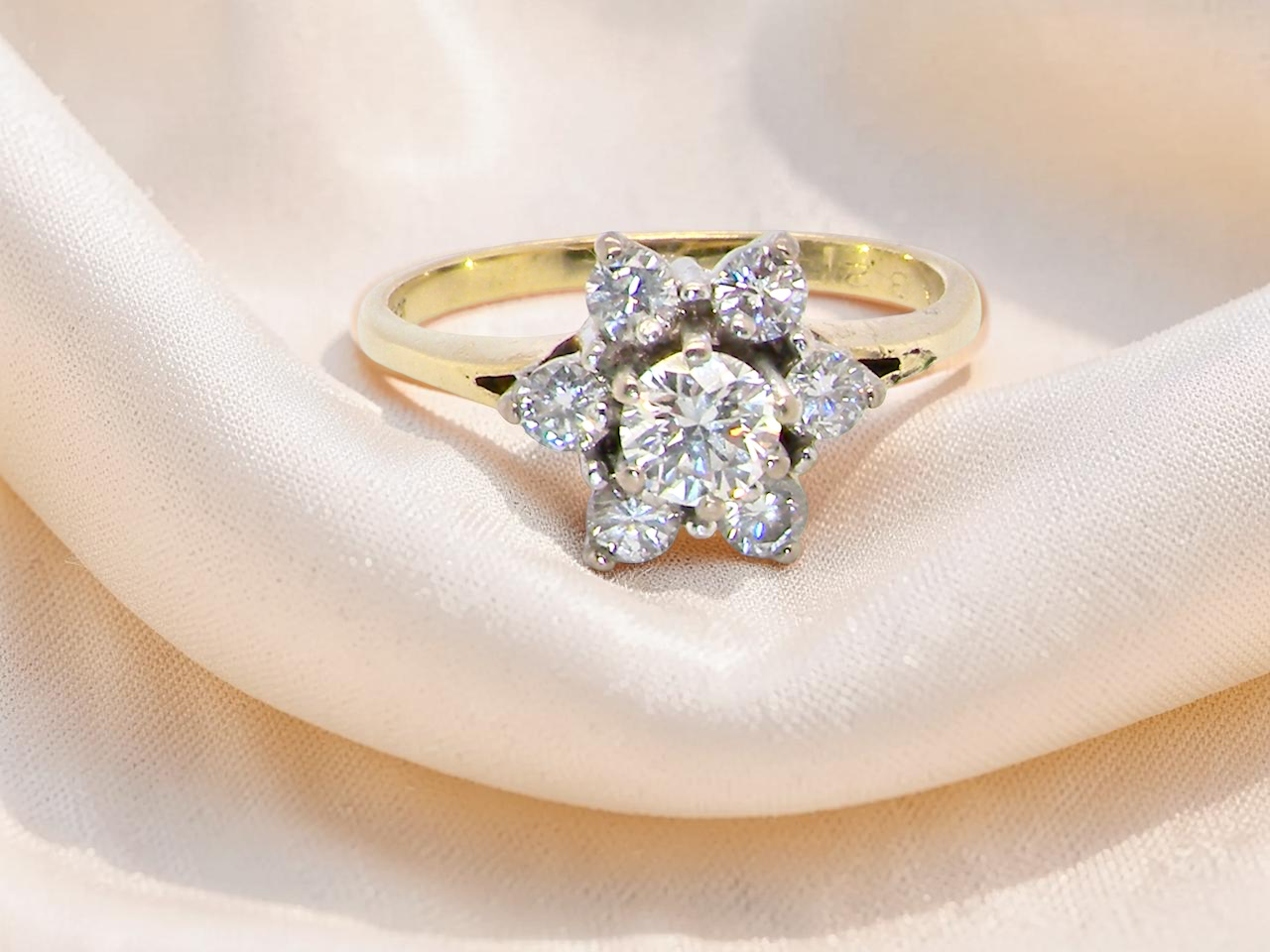 A beautifully crafted vintage diamond cluster ring, dating to the 1960s, featuring a classic floral-inspired design 