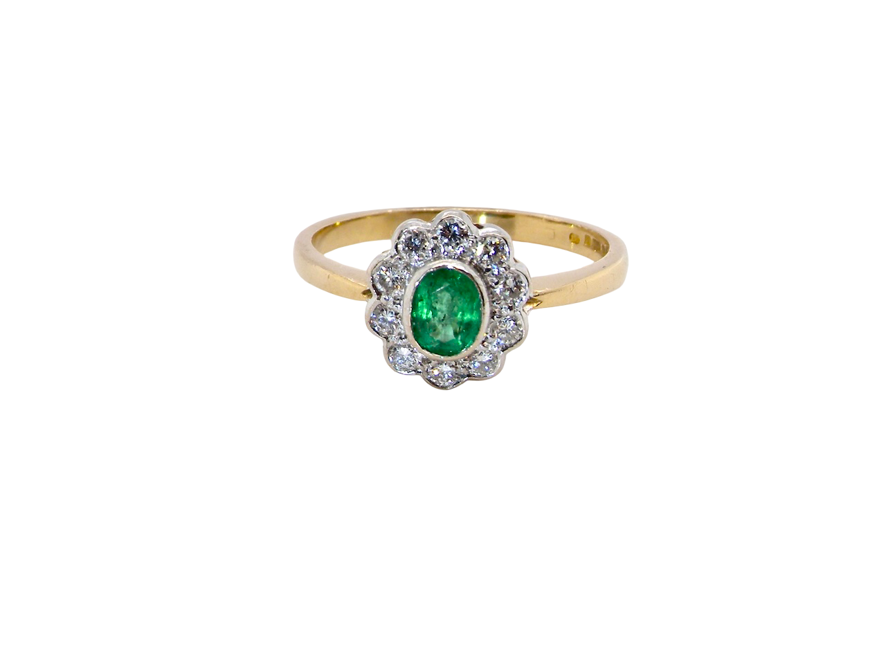A beautifully elegant cluster ring featuring a central oval-cut emerald, measuring 5 x 4mm (estimated 0.40 carats).