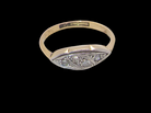 A vintage Art Deco style signet ring featuring a yellow gold band and a silver-toned oval face embellished with small round diamonds, shown against a solid black background.