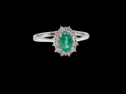 A classic cluster ring set with an oval cut emerald centre stone, measures 6x4mm, grass green colour.

Complimented by an outer halo of twelve brilliant cut white diamonds, 