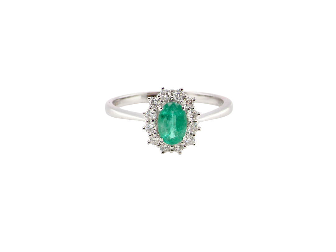 A classic cluster ring set with an oval cut emerald centre stone, measures 6x4mm, grass green colour.

Complimented by an outer halo of twelve brilliant cut white diamonds, each 1.7mm (total est at 0.25 carats)