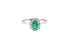 A classic cluster ring set with an oval cut emerald centre stone, measures 6x4mm, grass green colour.

Complimented by an outer halo of twelve brilliant cut white diamonds, each 1.7mm (total est at 0.25 carats)