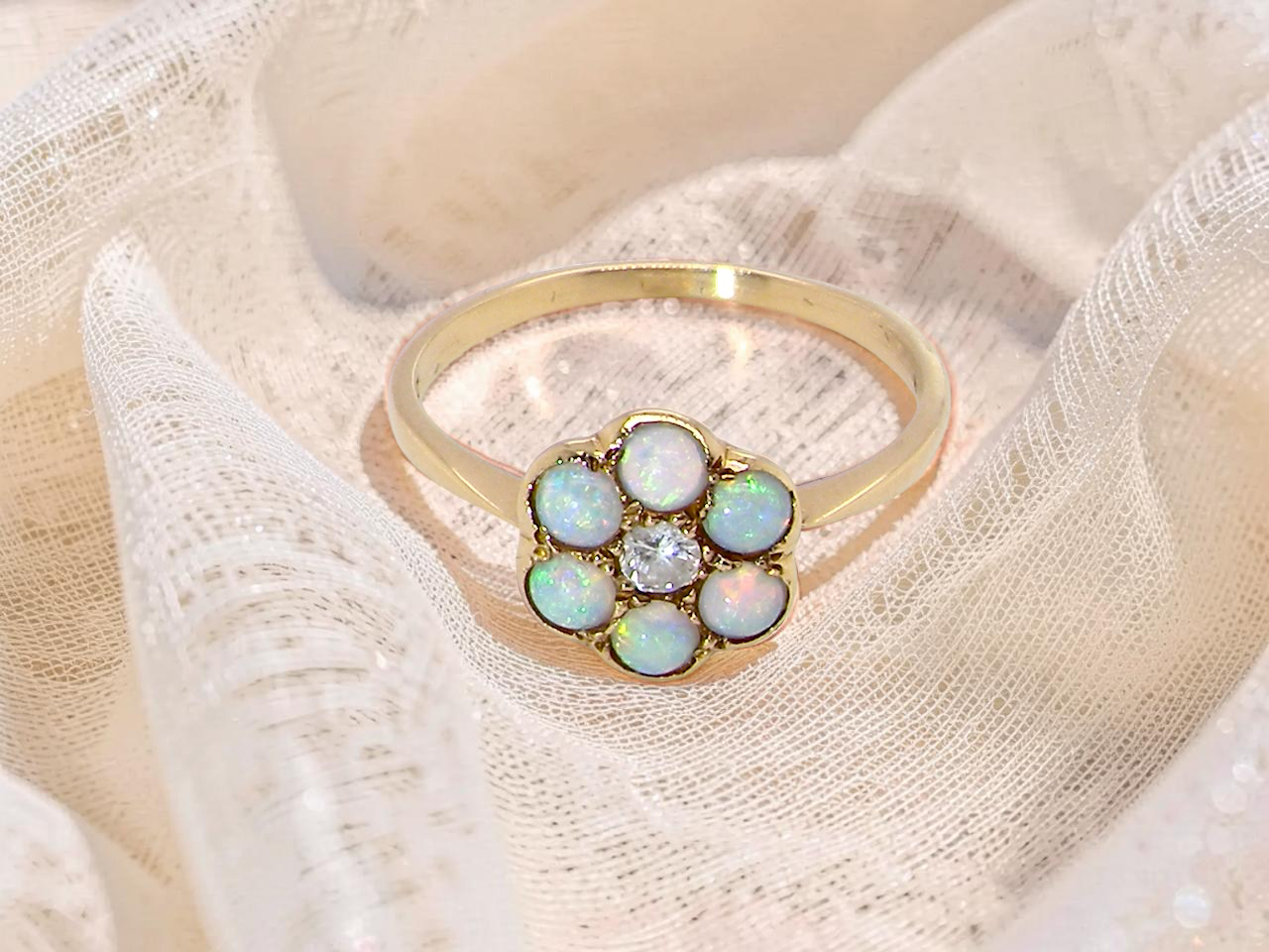 A daisy cluster dress ring. Set with a small diamond centre stone,  (0.10 carats)
