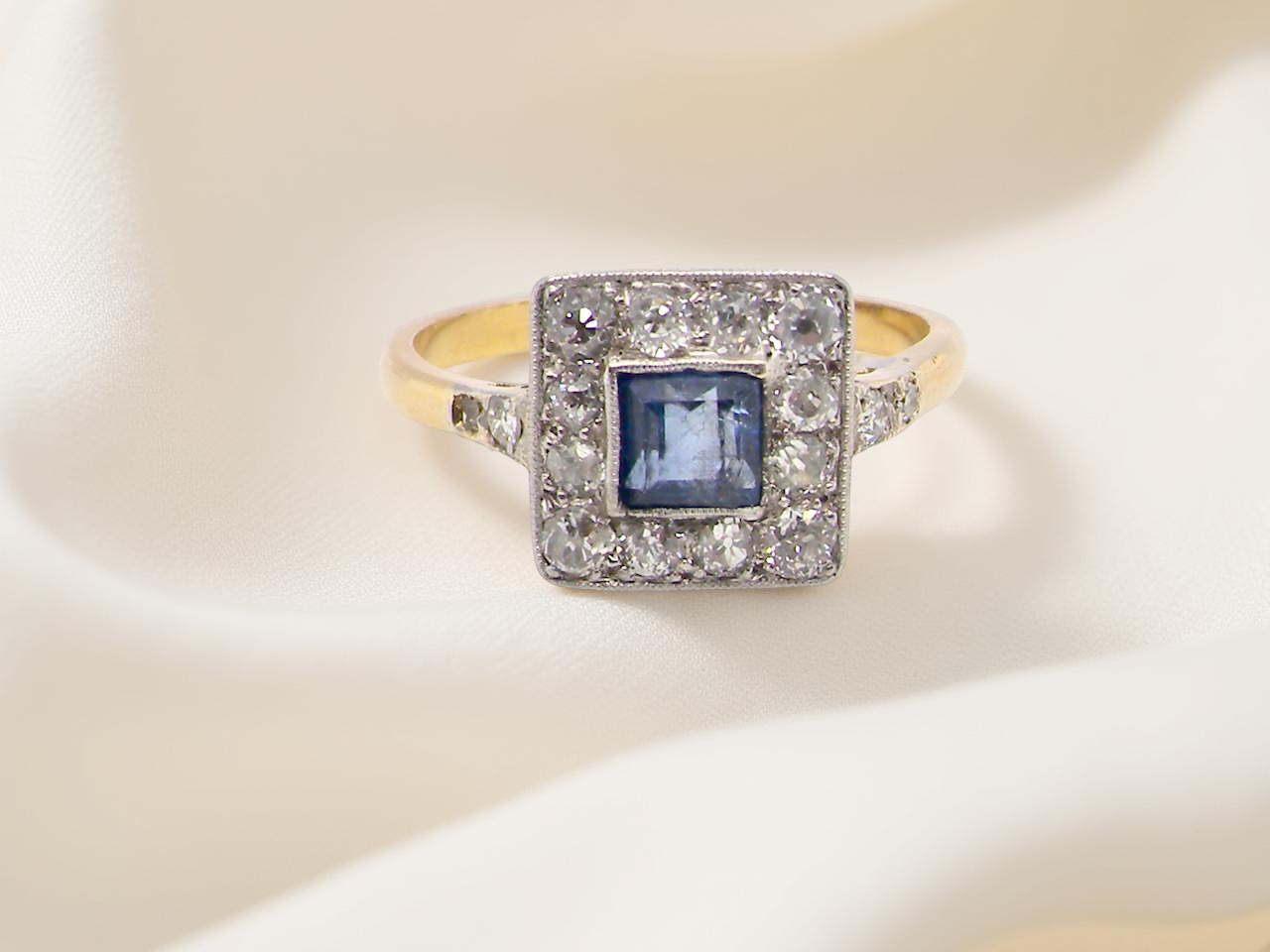 A fine Art Deco cluster ring. The centre stone a square sapphire 5x5mm (est 0.50 carats)  mille grain setting.
