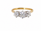 A three-stone diamond ring with a yellow gold band and silver-colored prongs holding three round brilliant-cut diamonds, shown on a plain white background.