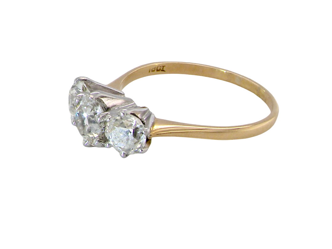 A three-stone diamond ring with a yellow gold band and silver-toned prong setting, shown on a plain white background.