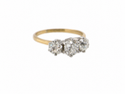 A vintage-style three-stone diamond ring with a yellow gold band and silver-toned settings, shown on a plain white background.
